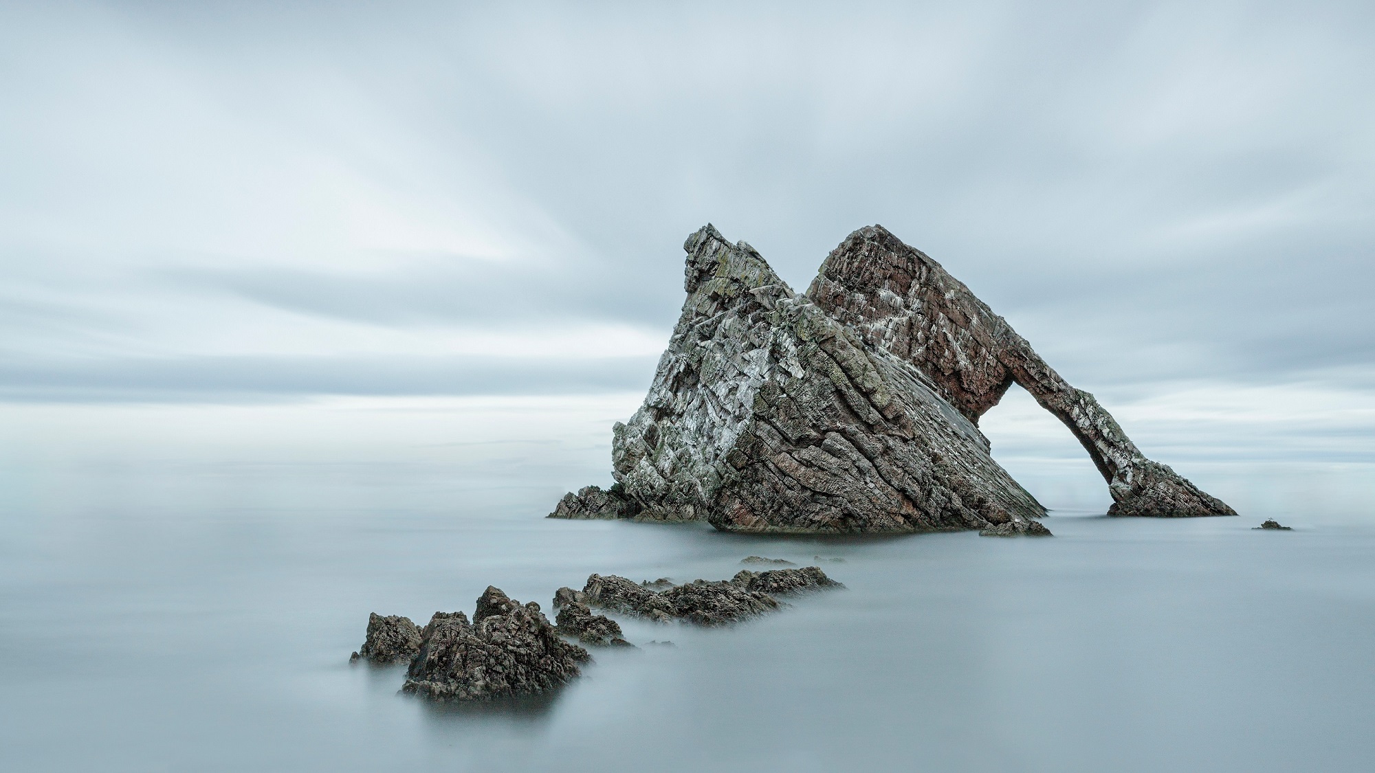 Banner image of bowfiddle rock - a rock formation in the sea that looks like a bow fiddle.